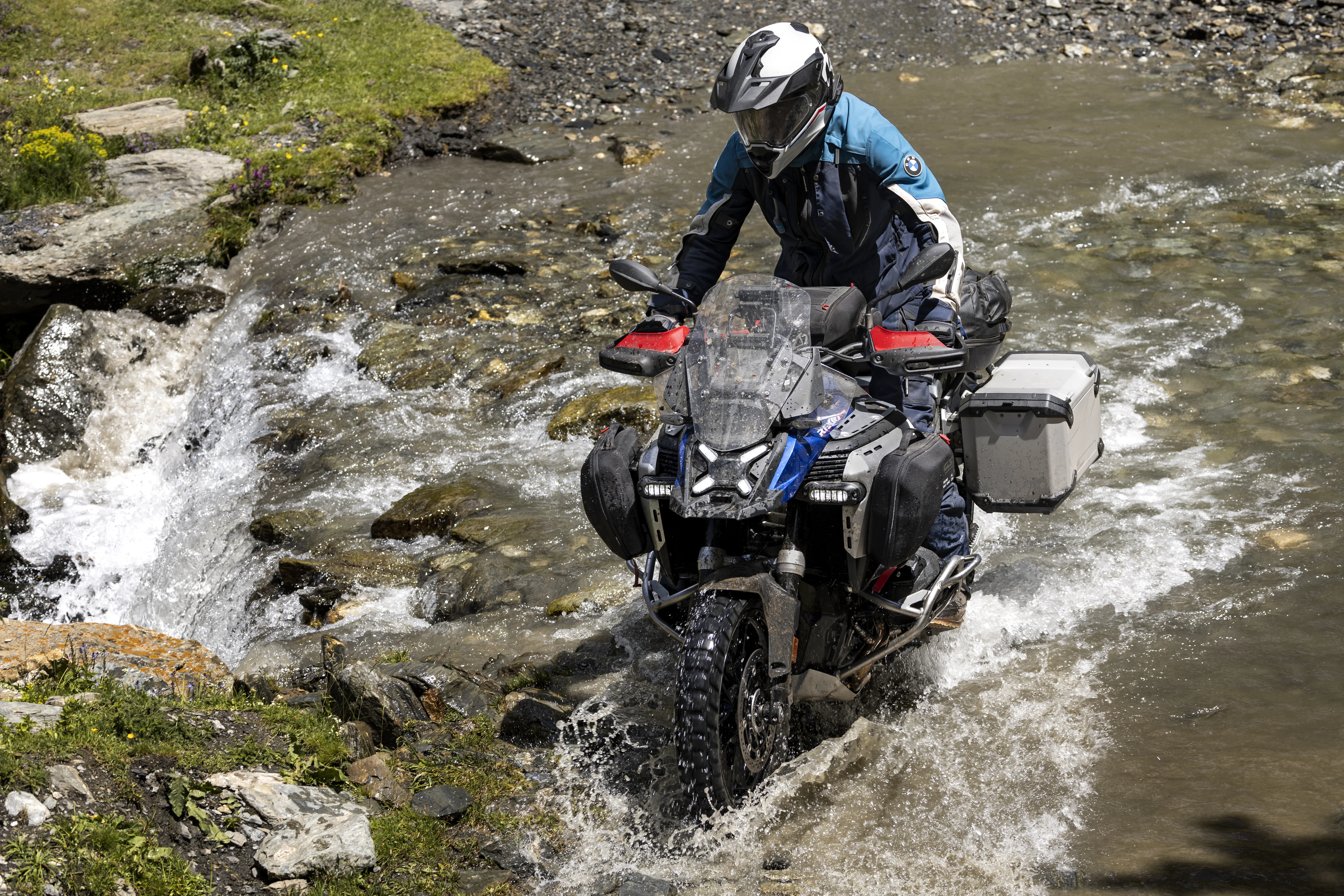 2026 BMW R 1300 GS Adventure crossing shallow water on a rocky trail.